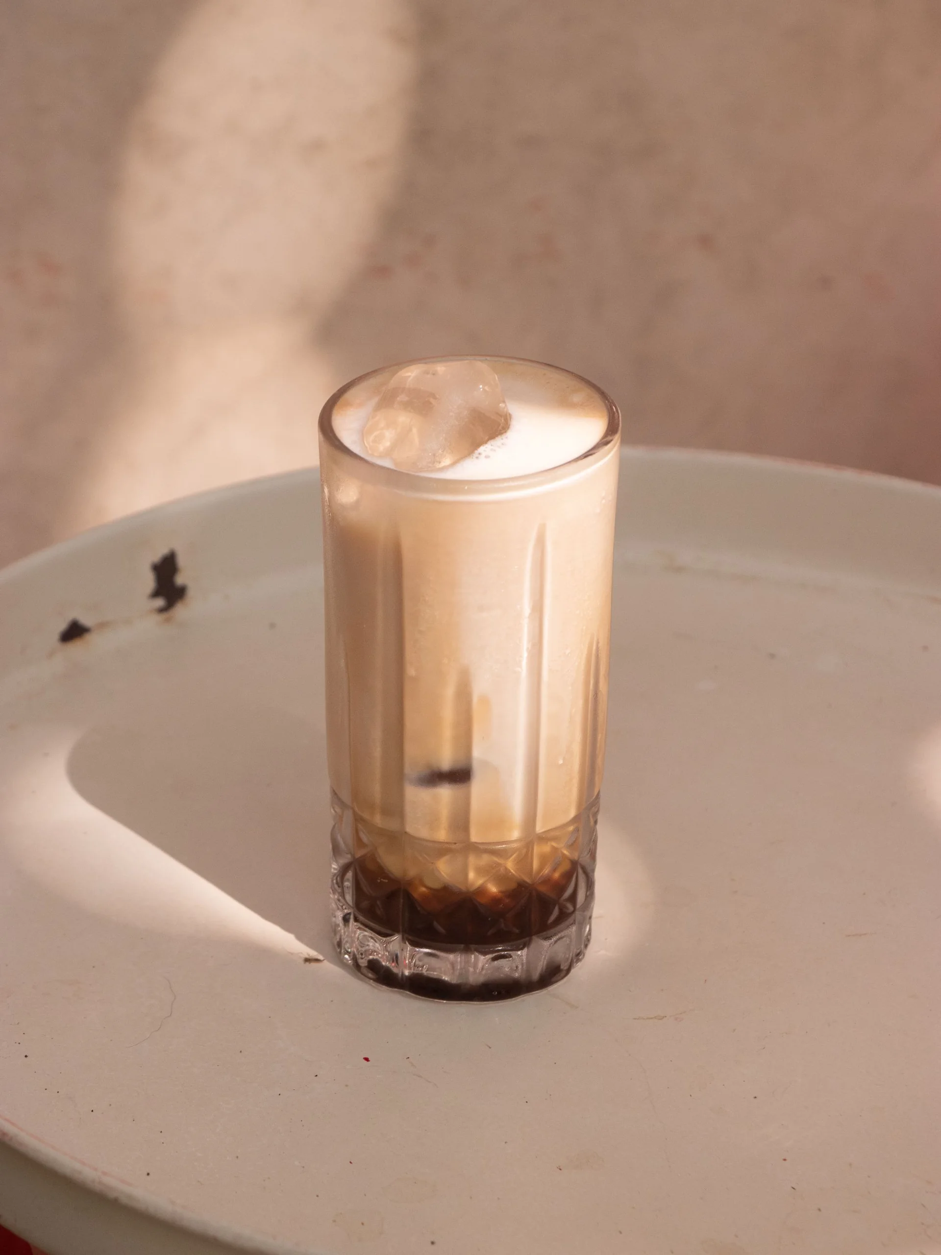 Iced Latte im Glas auf einem sonnigen Tisch – Stimmungsbild, kein nachgewiesenes PINE-NUT-LATTE-Rezept